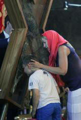 Vjernici koji se probijaju do krsta svetog Andrije Prvozvanog poljube svetište i nadaju se čudu. Fotografija.